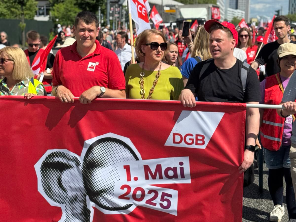 Lisa Paus läuft hinter dem Transparent des DGB.