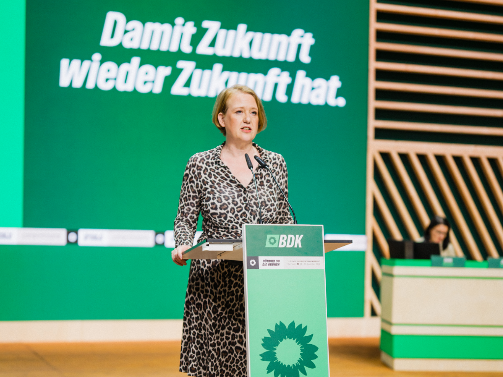 Lisa steht am Redepult und redet.